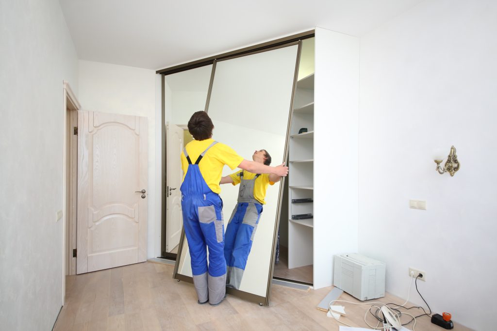 Worker,Setting,Mirrored,Doors,On,Corner,Sliding,Wardrobe,In,Room